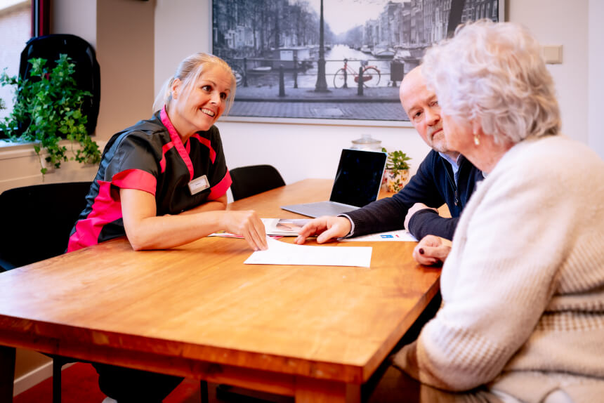 Medewerker met cliënt en mantelzorger