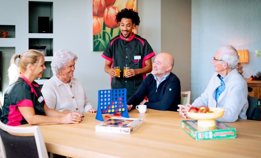 Bewoners spelen met medewerkers een spelletje vier op een rij