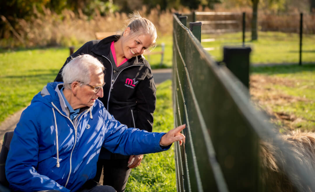 Medewerker en cliënt buiten aan het wandelen